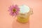 Sugar paste for depilation. Shugaring. Removing hair. Cosmetics. Honey in jar with flower on Living Coral background