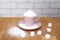 Sugar pouring in a pink tea cup and saucer, refined slices on a wooden table, concept of excess sugar consumption, diabetic, close