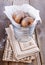 Sugar powdered cinnamon doughnuts in a metal bucket on rustic wooden background close up