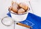 Sugar powdered cinnamon doughnuts in a metal rustic bowl on white wooden background with sieve close up