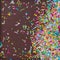 Sugar sprinkle dots, decoration for cake and bakery, as a background. On chocolate broun background,