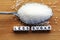 Less sugar text from tiled letter blocks and sugar pile on a spoon suggesting dieting concept