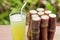 Sugarcane fresh juice for a detox diet - Organic fruits on wooden background. Closeup image / Selective focus