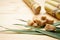 Sugarcane, green leaf and brown sugar on a wooden background, space for text. Close-up