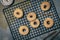 Sugared mini donuts with cinnamon on a cooling rack on a gray background