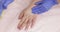 Sugaring depilation on hands and fingers in beauty salon, closeup