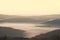 Suggestive landscape in Tuscany hills with morning fog and warm sunlight