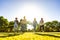 Suggestive low angle view of group of young multiracial gen-z friends running on green field with setting sun at their back with