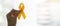 Suicide prevention and Childhood Cancer Awareness, Yellow Ribbon on wooden background  for supporting people living and illness.