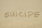 SUICIDE written on sand