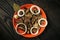 Suillus luteus or Boletus luteus mushrooms marinated in a plate with spices and bay leaves on a vintage table. Top view