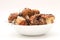 Suillus mushrooms in a ceramic soup plate isolated on a white background. Armful of dirty, unpeeled, butter fungi