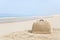 Suitcase made out of sand on beach