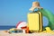 Suitcase and stylish beach accessories on seaside