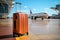 Suitcase in terminal airport, behind that\\\'s airplane park is going to flight and travel