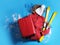 Suitcase with warm clothes and skis on blue background, flat lay. Winter vacation