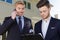 suited men with clipboard and smartphone outside residential property