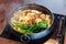Sukiyaki hot pot with boiling vegetables including cabbage, konjac noodle, onion, carrot, shiitake, enokitake and tofu.