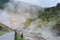 Sulphurous mountain valley with hot spring stream and steam at Tamagawa Onsen Hot spring in Senboku city, Akita prefecture, Japan