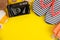 summer accessories with shells, flip flops, a camera on a bright yellow background. top view