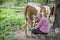 In the summer afternoon  a woman milks a cow on the street