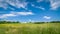 summer agricultural landscape. a hilly field under a blue cloudy sky