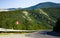 Summer asphalt road in the mountains, leading over the hill.