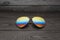 Summer aviator sunglasses with mirrored color lenses made of glass in a metal frame of gold color on a black background