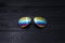 Summer aviator sunglasses with mirrored color lenses made of glass in a metal frame of gold color on a black background