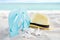 Summer background banner with flip flops. Vacation holiday accessories on beach. Slippers, hat and shell on sand near ocean.