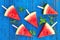 Summer background. Watermelon fruit slice popsicles on a blue w