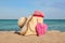 Summer bag with slippers, beach towel and straw hat on sand near sea