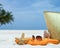 Summer beach bag with coral,towel and flip flops on sandy beach