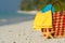 Summer beach bag with shell, towel on sandy beach