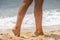 Summer, beach, leisure and body part concept - closeup of woman legs on sea shore