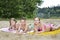 In summer, on the beach near the river are children in the sand.