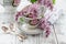 Summer blooming bouquet of lilac and china cup with black tea