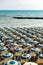 Summer blue yellow beach umbrellas on a sand in the morning, Adriatic sea coast,