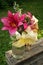 Summer bouquet of lilies and phlox in a glass vase on a wooden base