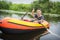 In summer, the boy floats on the river in an inflatable boat. He shows his hand super