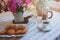 Summer breakfast in cozy country house. Table with bouquet of flowers from own garden, french press with coffee and cookies.