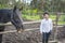 In summer  on a bright sunny day  a boy stands next to a horse on a ranch