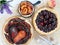 Summer cakes made from cherries, pears and peaches. Pies are located on a white wooden vintage background. Bouquet of wildflowers