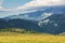 Summer carpathian landscape with green field and road