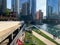 Summer in Chicago enjoyed around the Chicago River as commuters hurry on upper Wacker Drive, and view of lounge chairs, water tax