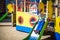 Summer, childhood, leisure, friendship and people concept - happy little boy on children playground slid from the hill