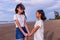 Summer, childhood, leisure and people concept-two female asian siblings hold each other`s hands