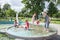 In the summer, children play in the fountain in the park.