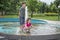 In the summer, children play in the fountain in the park.