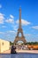 Summer city landscape - view of a woman tourist hiding from the heat in the shade against the background of the Eiffel Tower